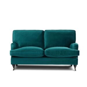 Emerald green velvet loveseat with plush cushions and rolled arms on small casters, evoking elegance and comfort in a modern setting.