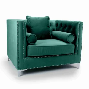 Luxurious green velvet armchair with a plush cushion and two cylindrical bolster pillows, accented with silver studs for an elegant, sophisticated look.